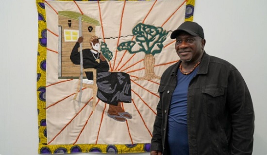 Gary Tyler poses with quilt acquired by the City